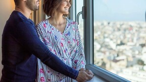 A couple standing by a window overlooking a cityscape. - Novotel Casablanca City Center (Casablanca)
