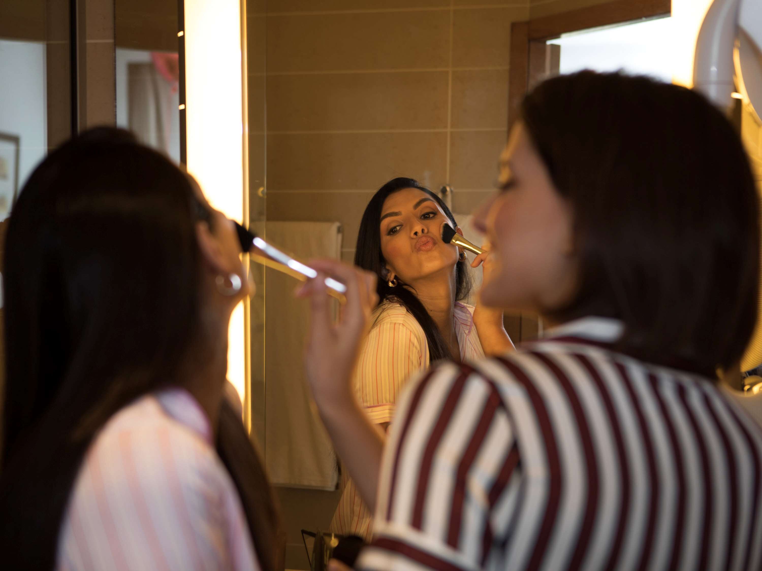 Une personne qui se maquille devant un miroir.