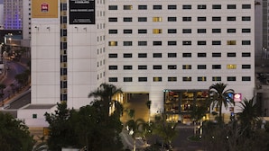 A high-rise hotel with multiple floors, prominent signage for 'Novotel' and 'Hotel ibis', and a large billboard advertising 'Allo ibis'. - Novotel Casablanca City Center (Casablanca)