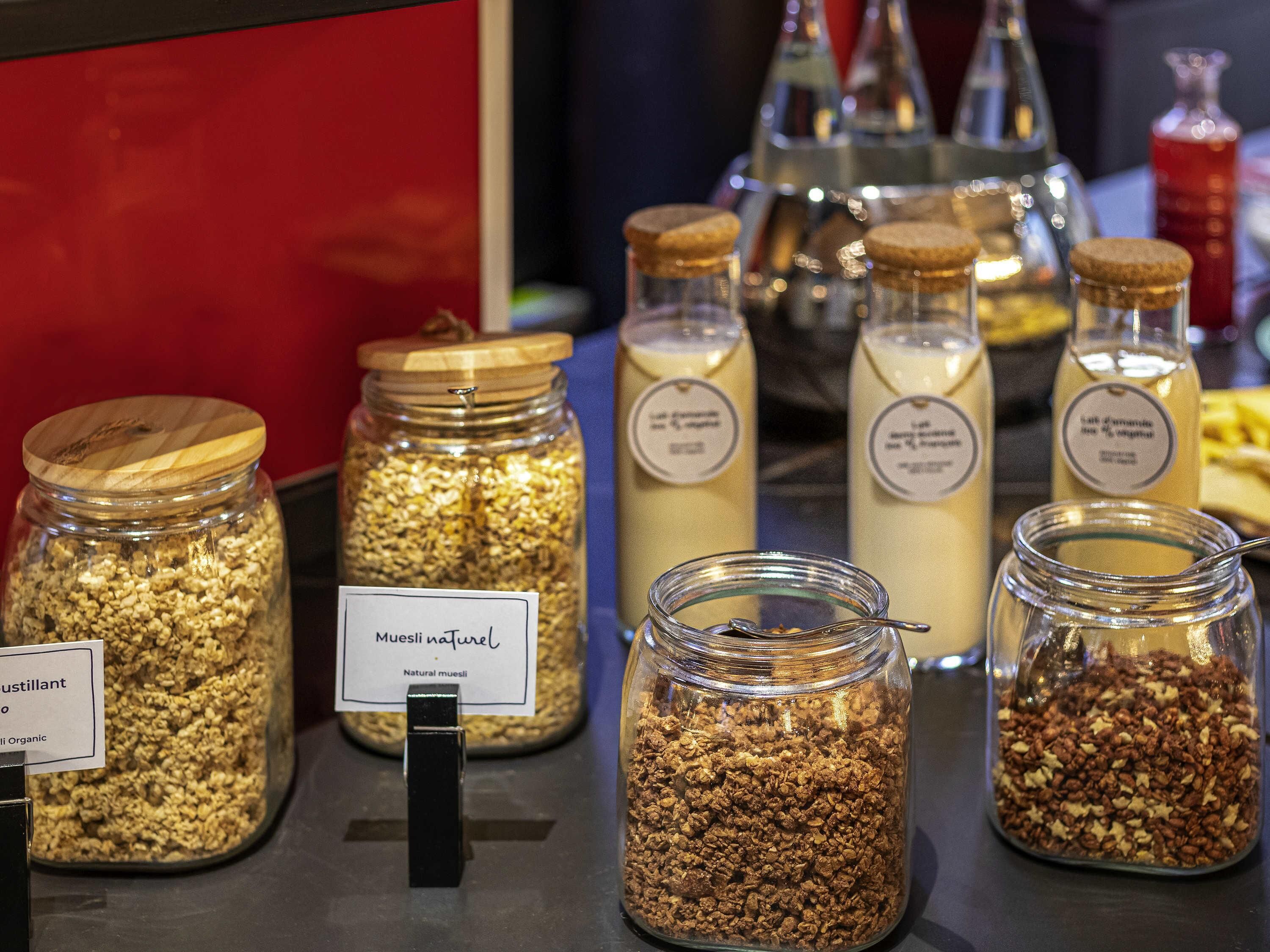 Una exhibición de diversos alimentos en frascos de vidrio con etiquetas, incluyendo un frasco etiquetado como 'Muesli natural'.