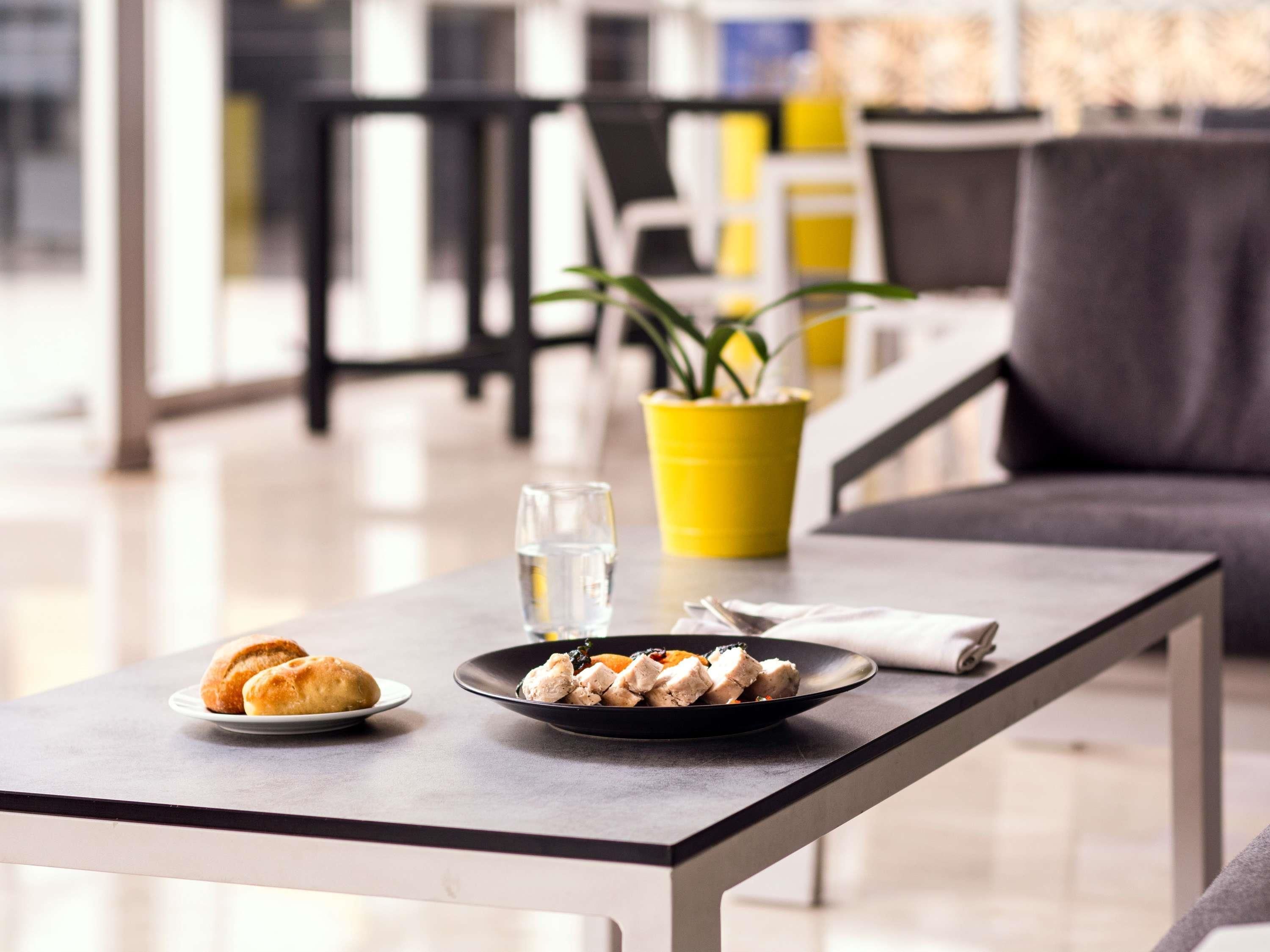 Une table à manger avec une assiette de nourriture, un verre d’eau et une serviette.