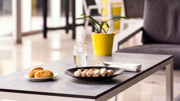 Une table à manger avec une assiette de nourriture, un verre d’eau et une serviette.