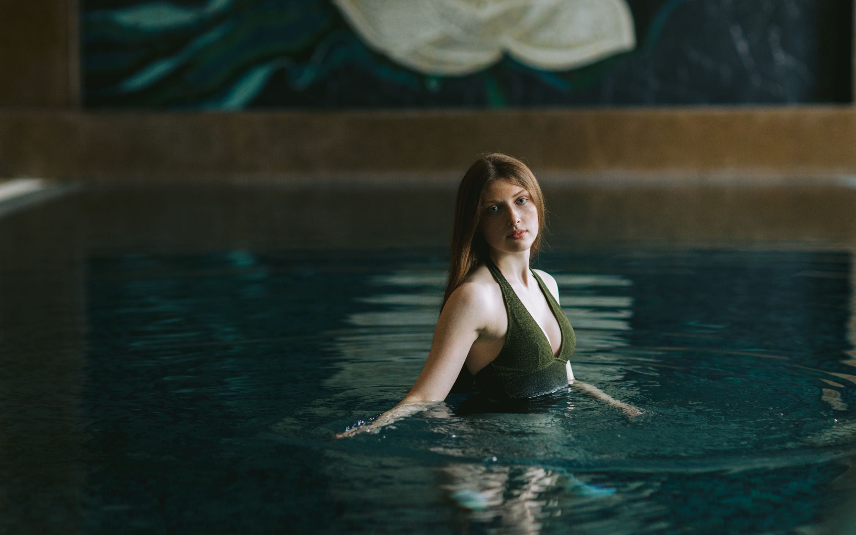 Una persona en una piscina, con el fondo desenfocado.