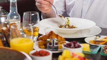 A dining table with various dishes, including a salad, fruit, and condiments.