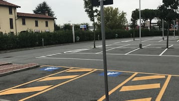 Un área de estacionamiento con espacios designados para personas con discapacidad, señalizados con símbolos azules y amarillos.