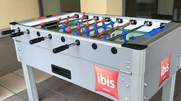 Ein Kicker mit dem ibis Hotels Logo, draußen auf einer gefliesten Fläche platziert.