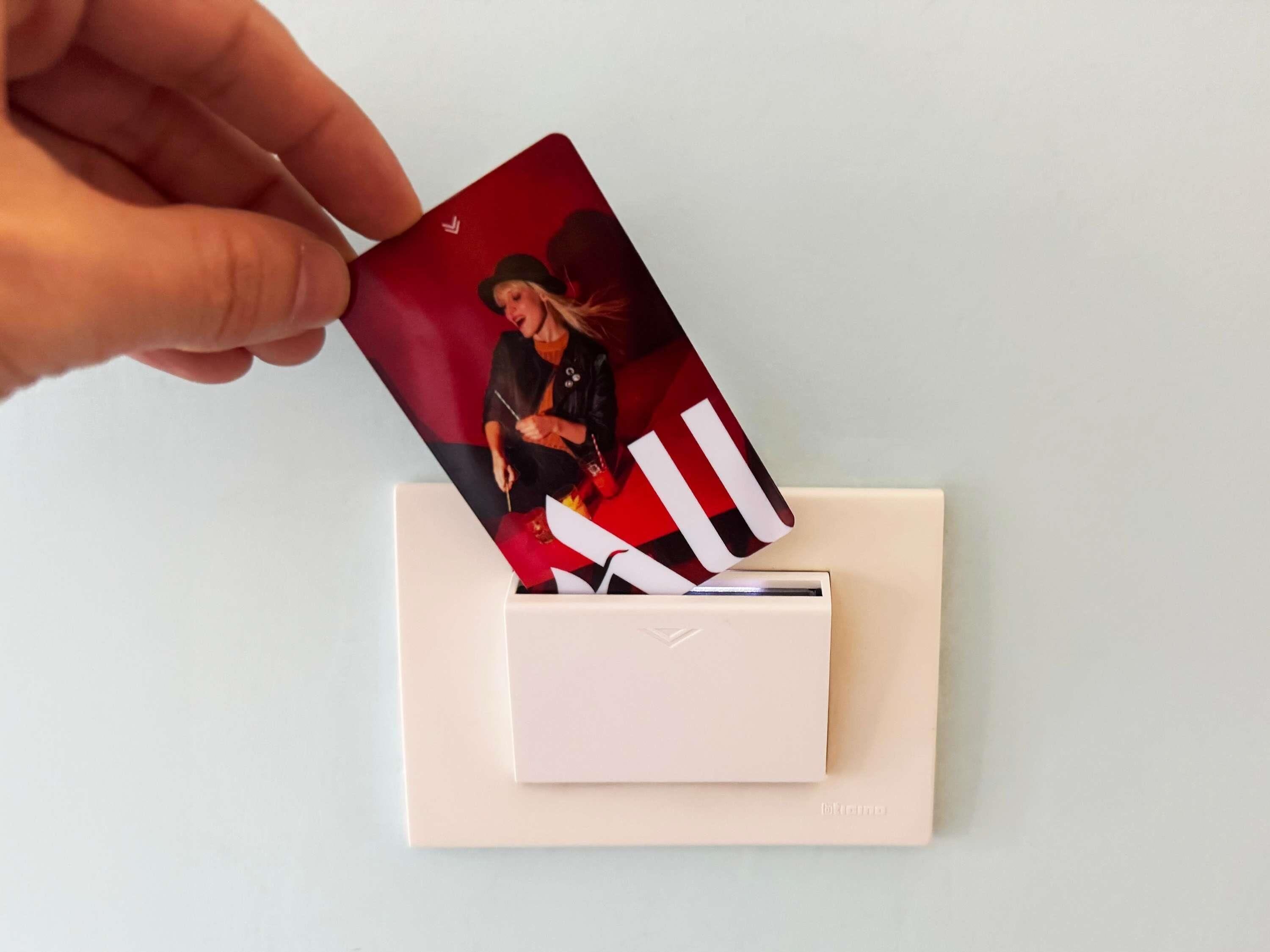 A hand placing a card into a white envelope.