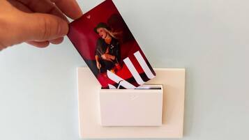 A hand placing a card into a white envelope.