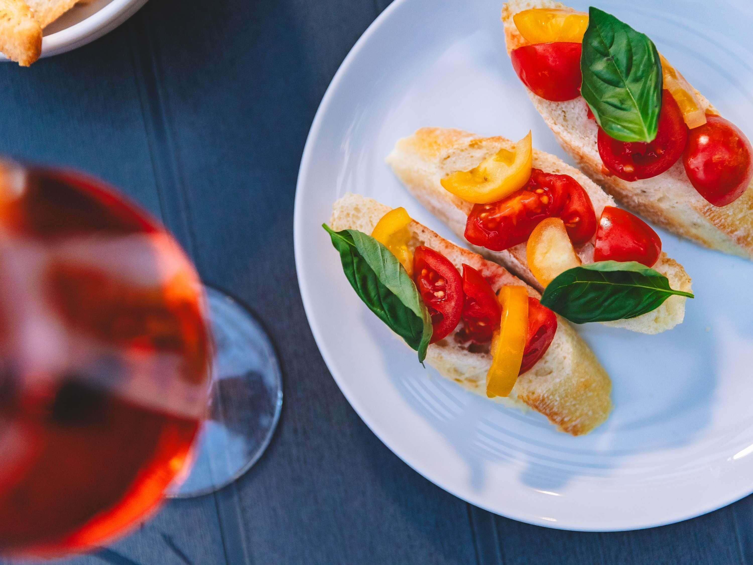 Un plato de bruschetta con tomates, pimientos y albahaca.