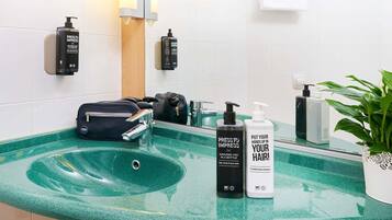 Ein Badezimmer mit einem grünen Marmorwaschbecken, einem Spiegel, einem Handtuchhalter und Toilettenartikeln.