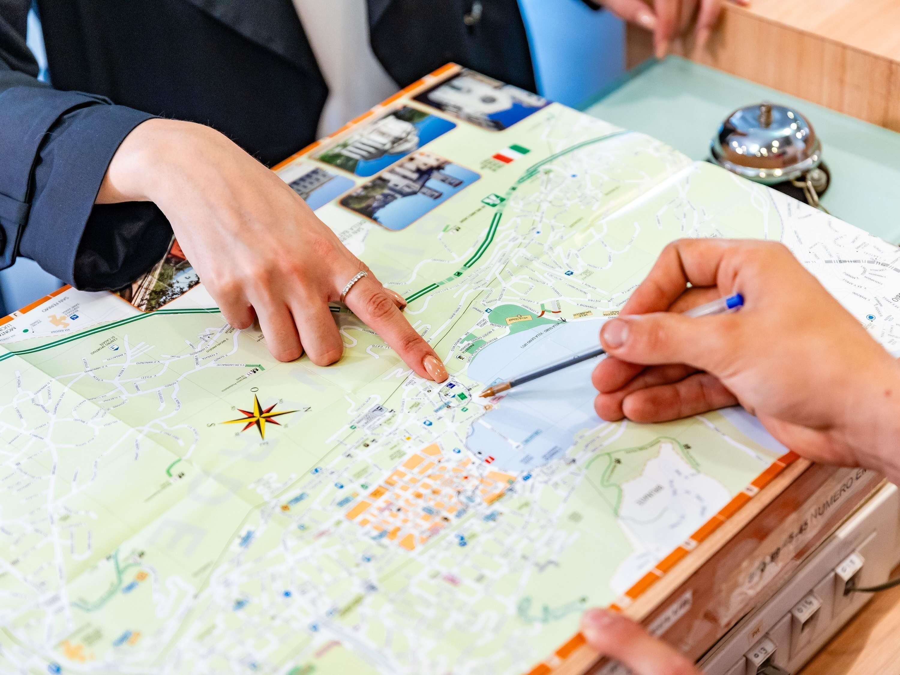 Eine Person zeigt auf eine Karte mit einer Kompassrose, was auf Navigation oder Routenplanung hinweist.