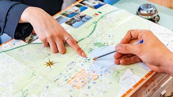 Eine Person zeigt auf eine Karte mit einer Kompassrose, was auf Navigation oder Routenplanung hinweist.