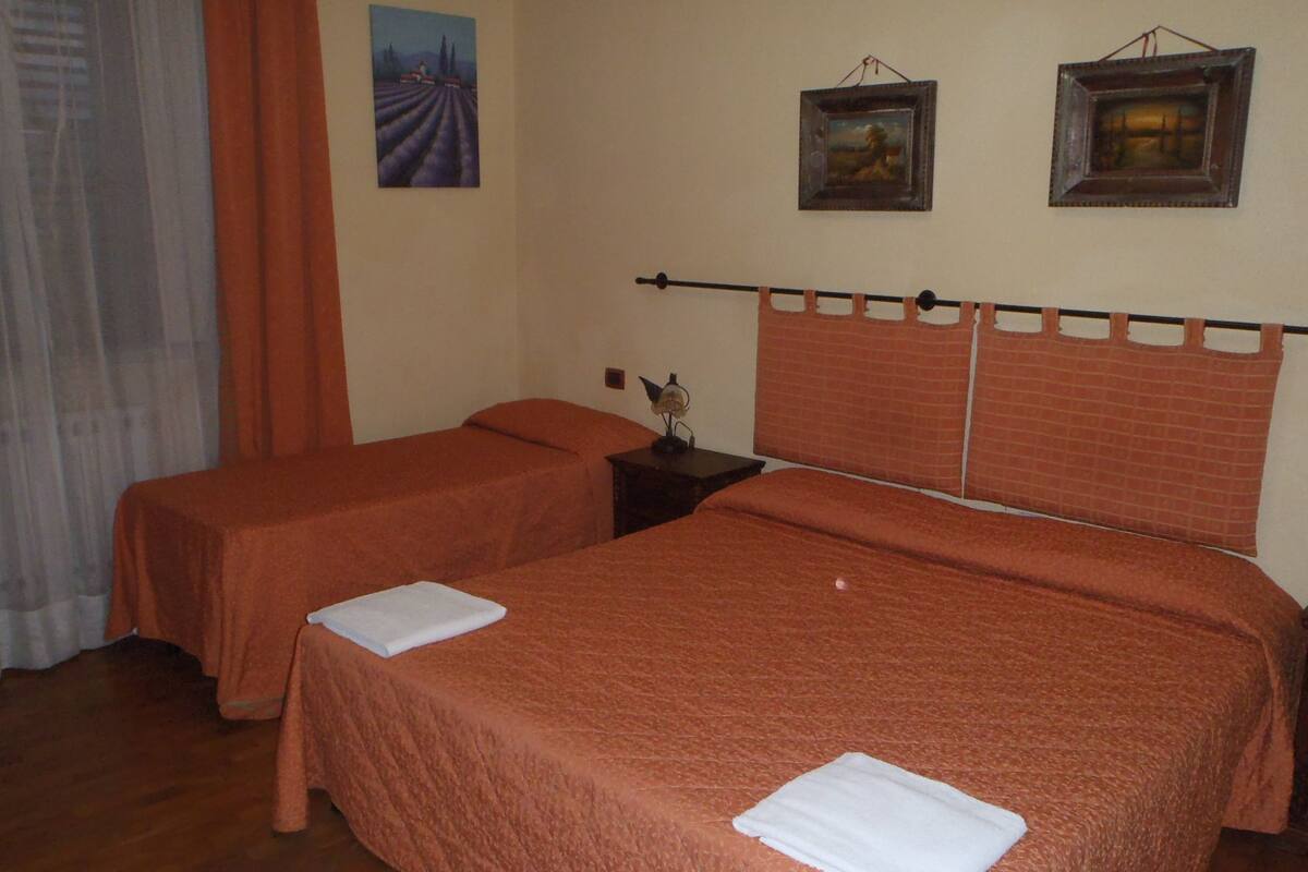 Une chambre avec deux lits, chacun doté d’une tête de lit et d’un pied de lit assortis, et une table de chevet placée entre les deux.