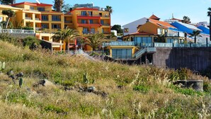 A coastal hotel with multiple floors, balconies, and a pool area. - Cais da Oliveira (Santa Cruz)
