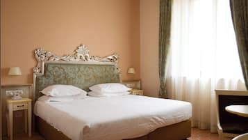 Una camera d'albergo con un letto grande, due comodini, una sedia e una finestra con tende.