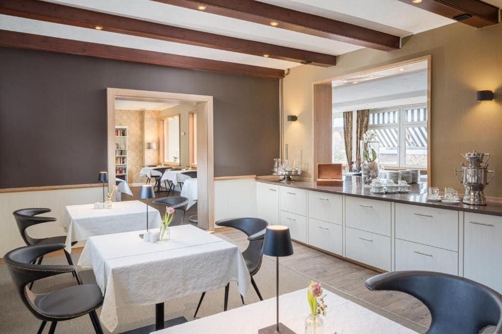 A modern dining area with tables, chairs, and a kitchen counter.