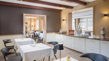 A modern dining area with tables, chairs, and a kitchen counter.