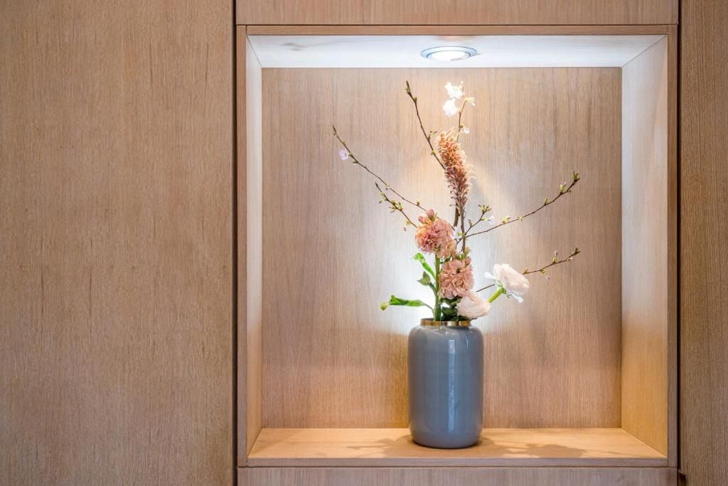 A wooden cabinet with a vase containing flowers.