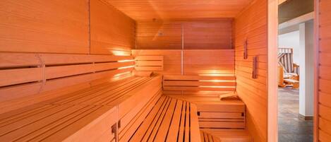 A sauna with wooden benches and a sloped ceiling.