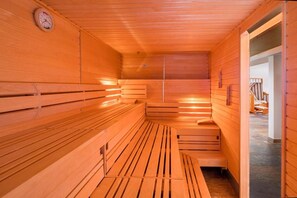 A sauna with wooden benches and a sloped ceiling. - AKZENT Hotel Dorn (Büsum)