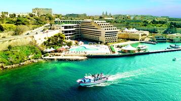 Un hôtel situé sur la côte, doté d’une piscine, d’un port de plaisance et offrant une vue sur le paysage urbain.