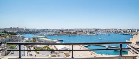 A balcony with a view of a harbor, including boats and buildings.