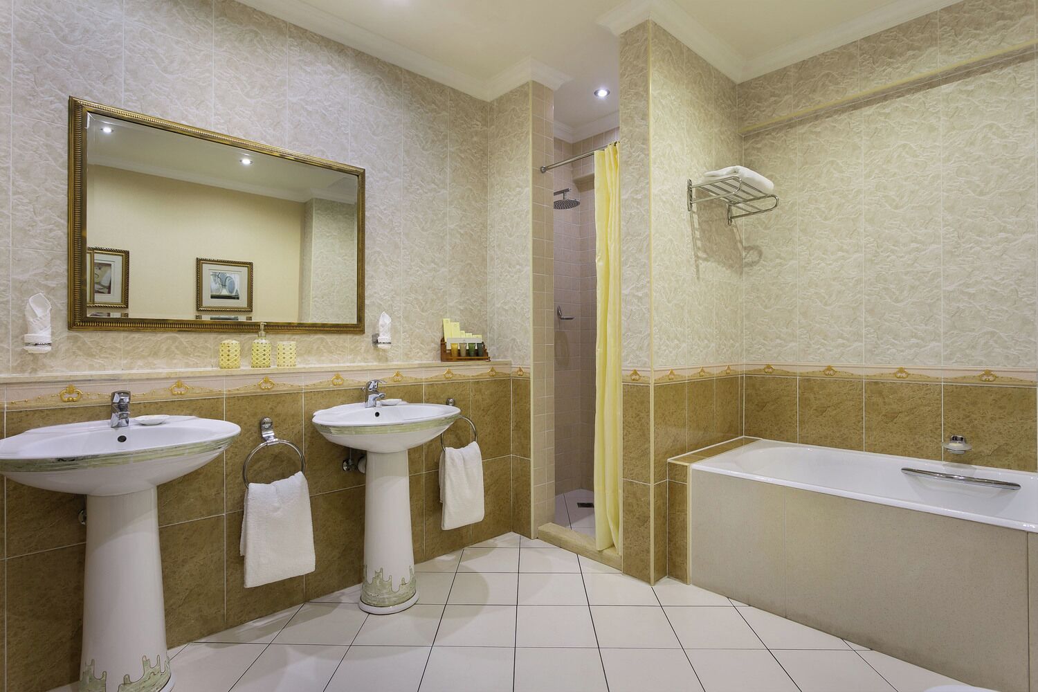A bathroom with two sinks, a bathtub, a shower, and a large mirror.