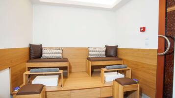 Une pièce compacte et moderne, dotée de deux bancs en bois et d’une petite table, ainsi que de tiroirs de rangement et d’un banc avec assise.