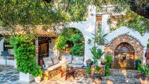 A courtyard with stone flooring, outdoor seating, and potted plants. - Acrotel Athena Pallas & Residence (Sithonia)
