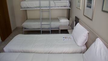 Habitación con literas, una cama individual y una silla.