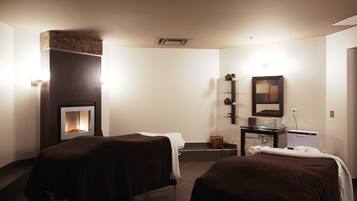Relax in comfort with two beds, a fireplace, and a wall-mounted mirror.