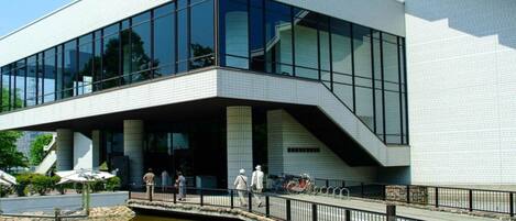 A modern building with large glass windows and a covered entrance area.