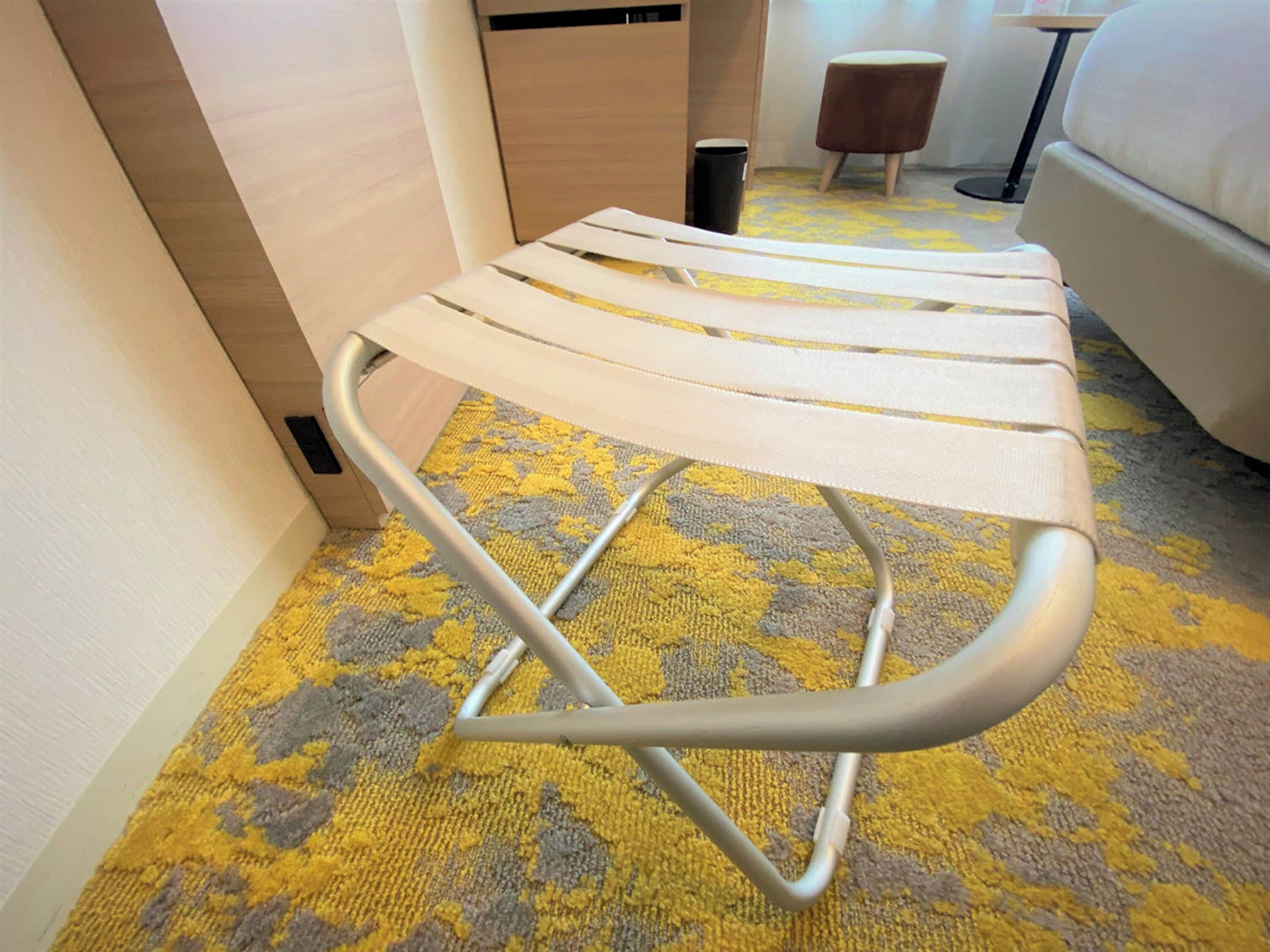 A room with a white sofa, a patterned carpet, and a small wooden table.