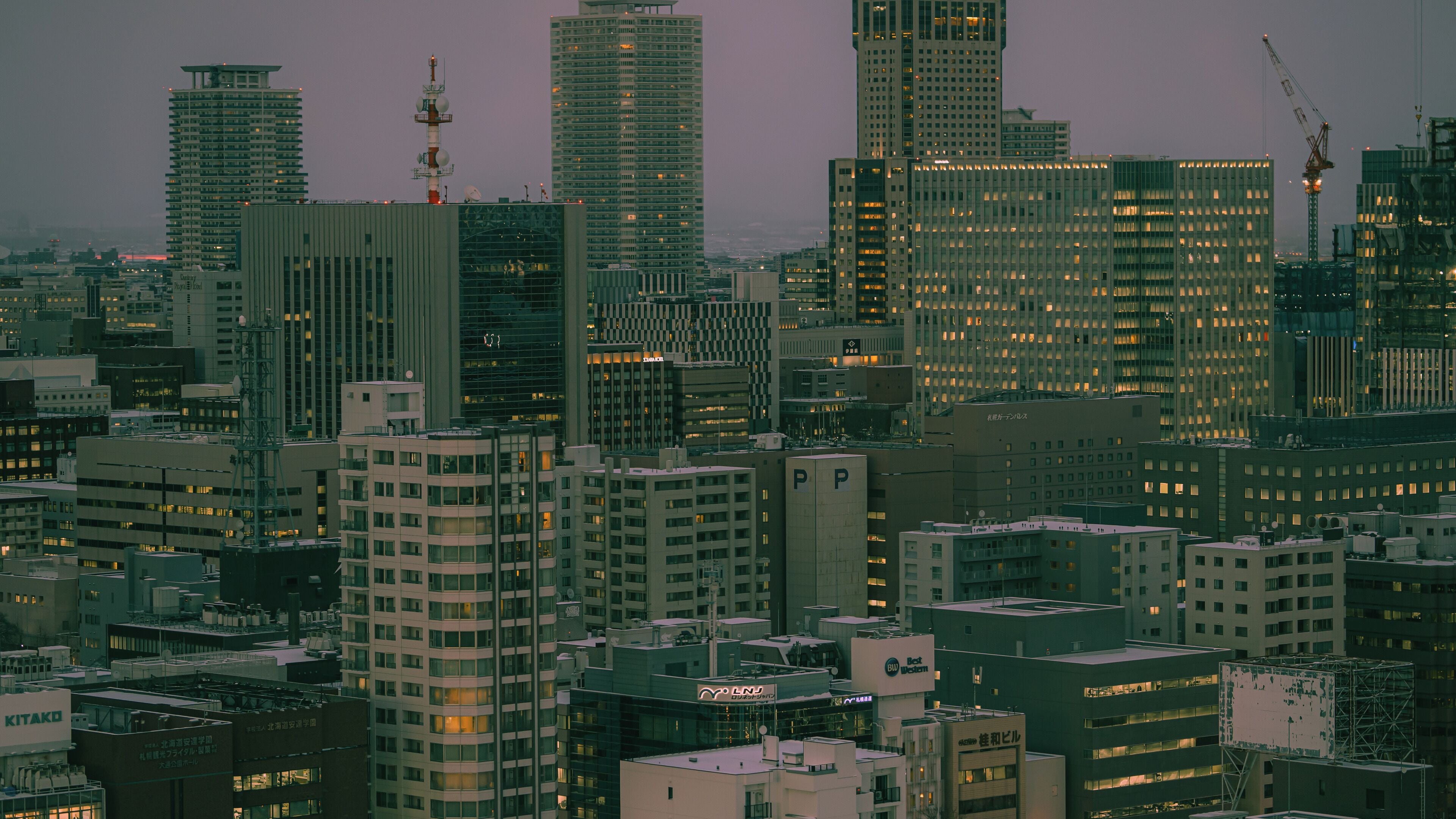 A cityscape with high-rise buildings, some with visible signage.