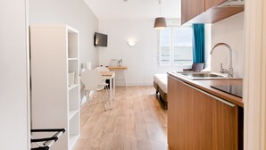 A compact kitchen with a wooden countertop, a built-in oven, and a sink. - Appart'Hotel Victoria Garden Pau (Pau)