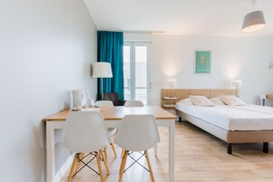Escritorio, cortinas blackout y tabla de planchar con plancha