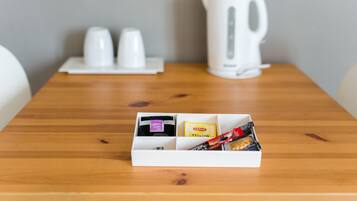 A wooden table with a white box containing Lipton tea and snacks.