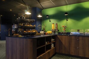 A kitchen with wooden cabinets, a counter with food items, and pendant lights.