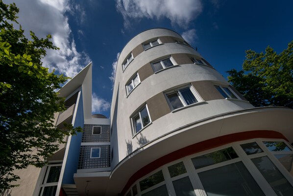 A multi-story building with a curved facade, large windows, and a prominent red stripe near the bottom. - Lagrange Apart'HOTEL Mulhouse (Mulhouse)