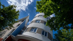 A multi-story building with a curved facade, large windows, and a view of the sky through the upper floors. - Lagrange Apart'HOTEL Mulhouse (Mulhouse)