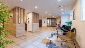 A modern lobby with a reception desk, seating area, and a large window. - Lagrange Apart'HOTEL Mulhouse (Mulhouse)