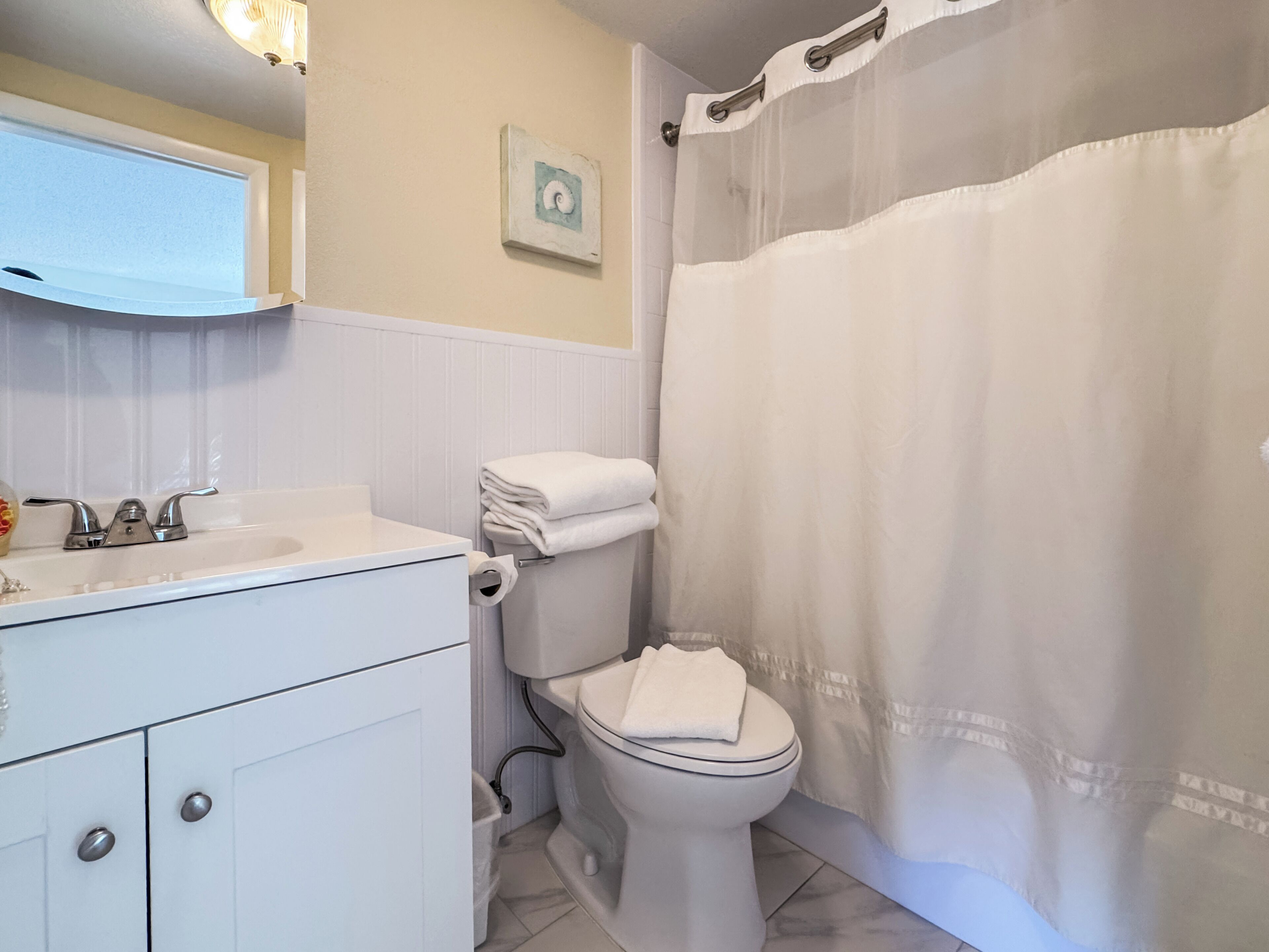 Une salle de bain avec des toilettes, un lavabo et un meuble de rangement.