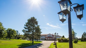 A pathway leading to a building with a large lawn and a clear sky. - Canadas Best Value Inn & Suites Summerside (North Bedeque)
