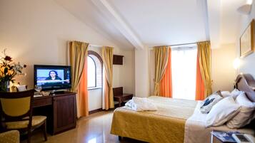 Habitació d'hotel amb un llit, una taula de nit amb televisió i una cadira.