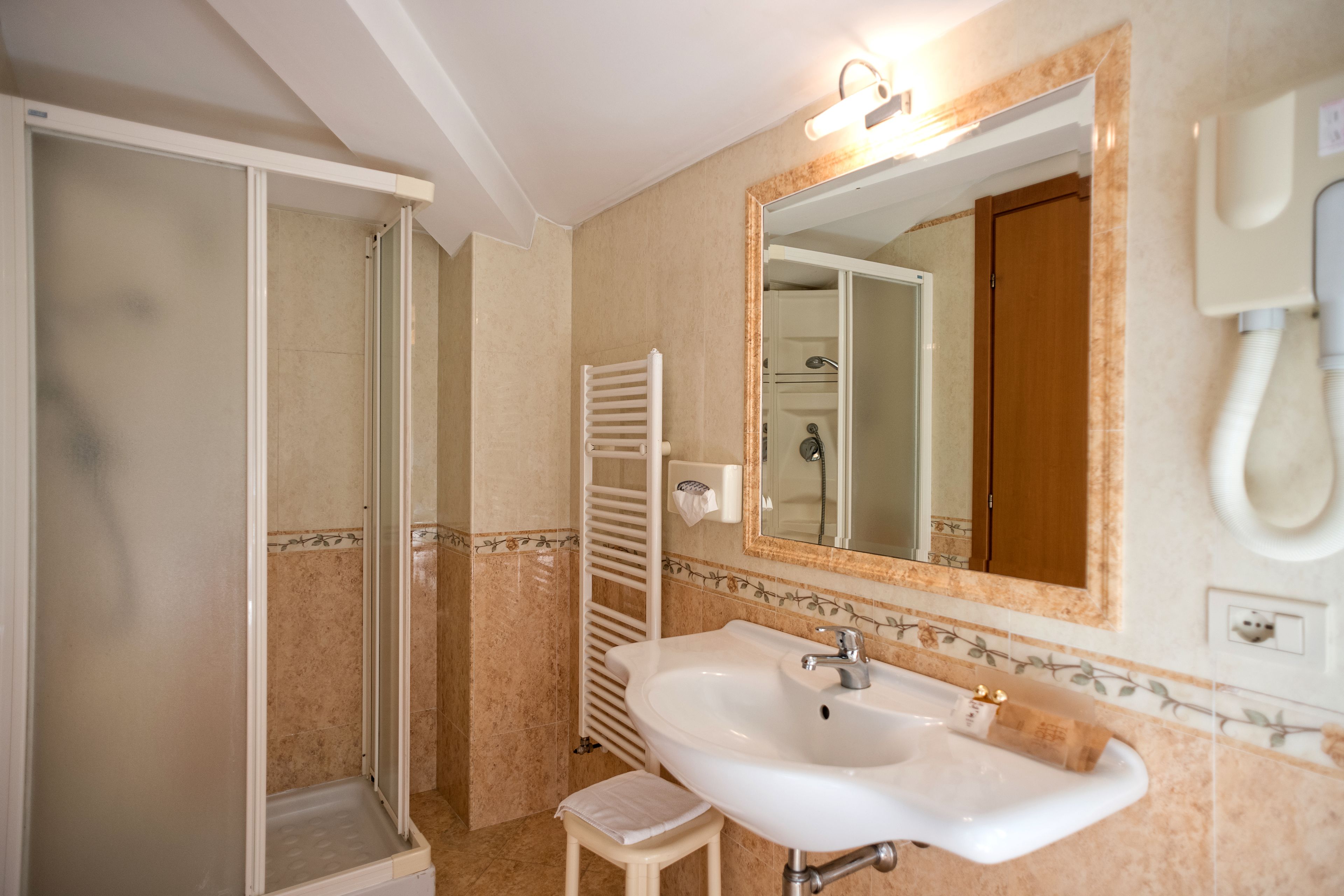 Un bagno con doccia, lavandino e specchio.