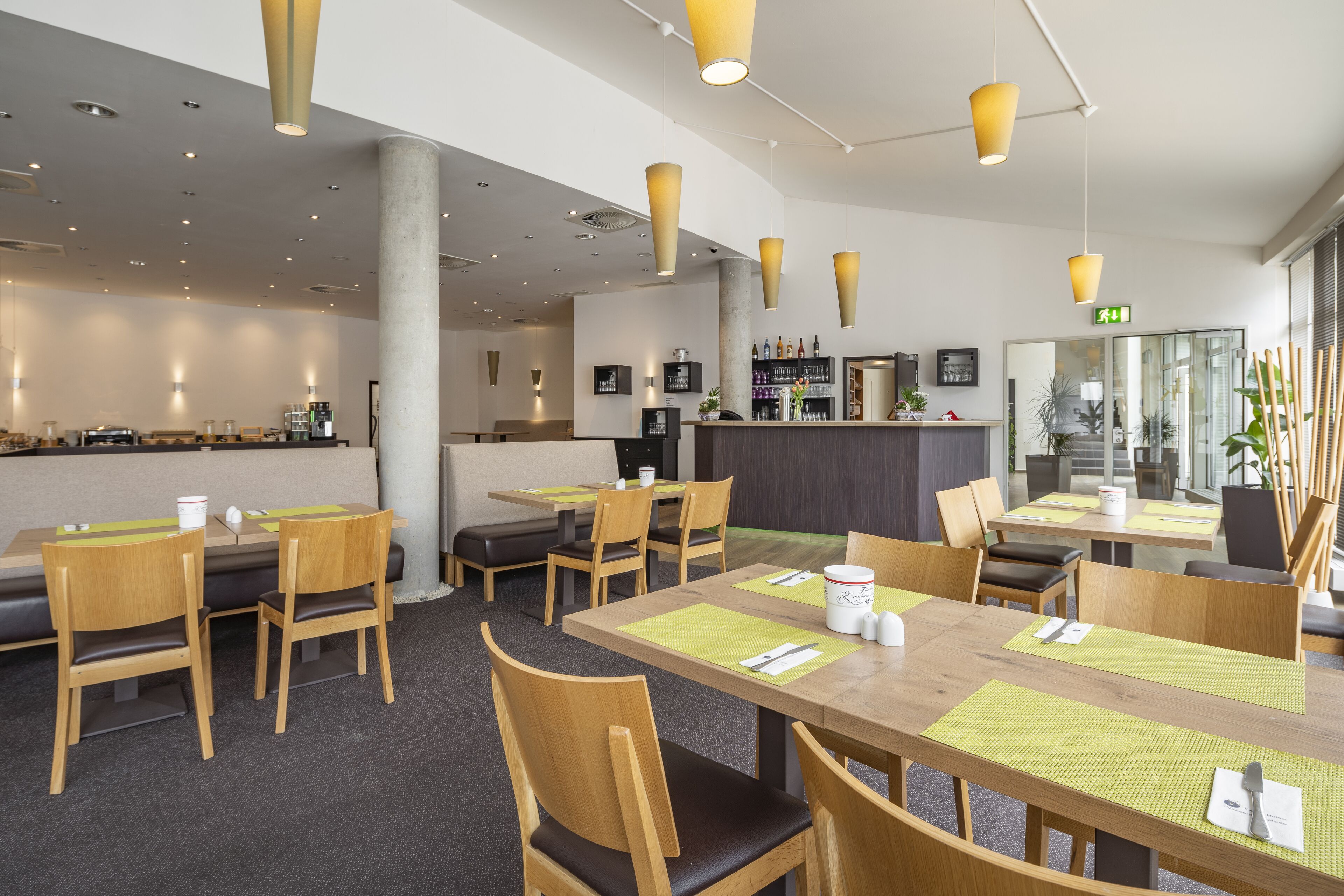 A modern hotel lobby with wooden furniture, a reception area, and a bar.