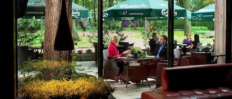 Frukost och lunch serveras, med utsikt mot trädgården