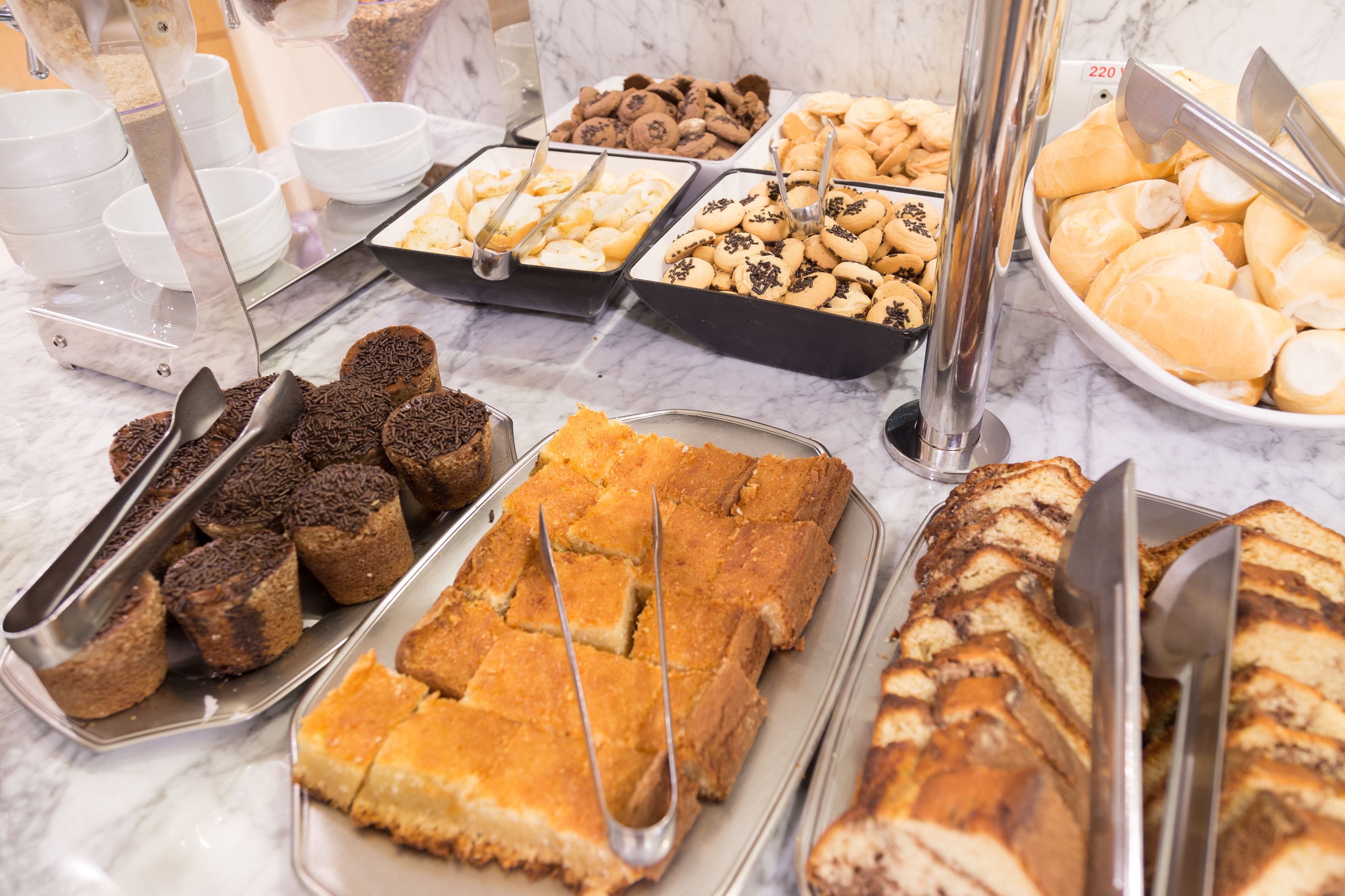 Un buffet proposant une variété de produits de boulangerie, notamment des biscuits, des brownies et des pâtisseries.