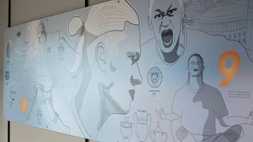 A wall with a large, detailed illustration of a football player in action, a trophy, and the number 9.
