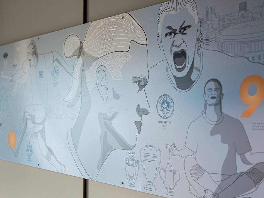 A wall with a large, detailed illustration of a football player in action, a trophy, and the number 9.